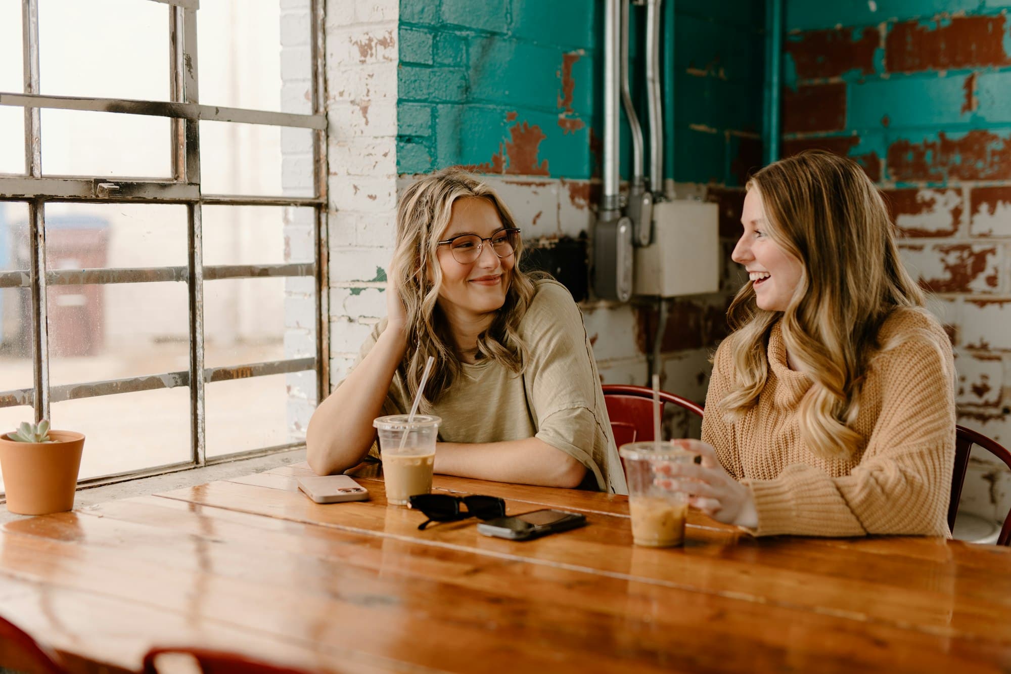 Two women talking and laughing over coffee