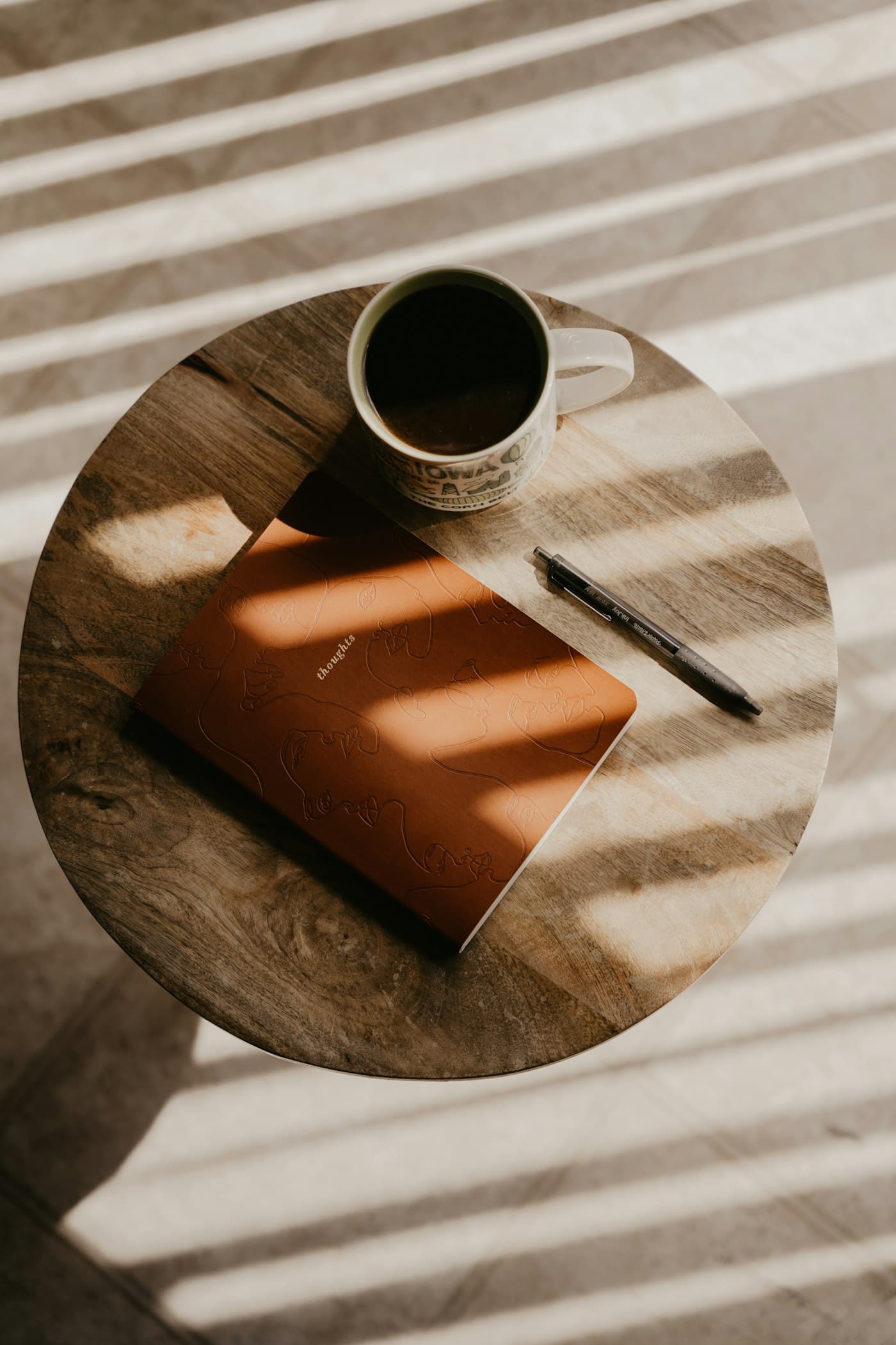 A notebook and coffee on a sunlit table